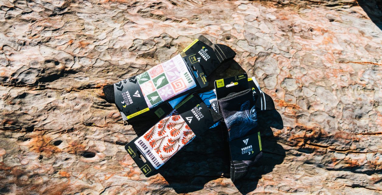 Packs of Outeniqua Bound socks resting on a rock