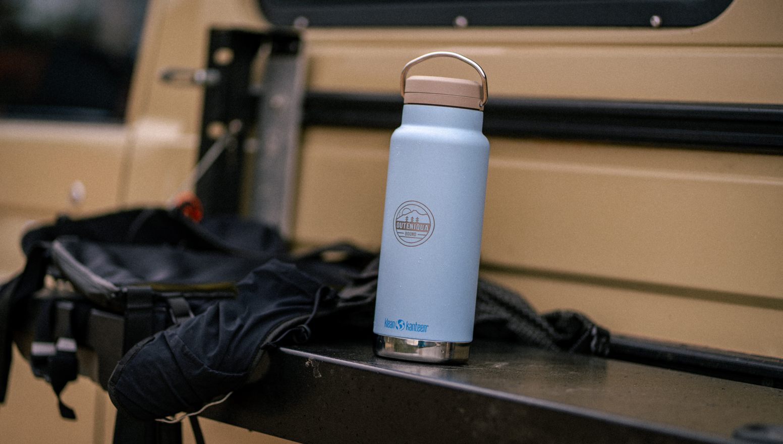 Water bottle and camping gear in the back of an overland vehicle