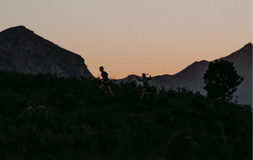 Hikers silhouetted on a mountain ridge at dusk