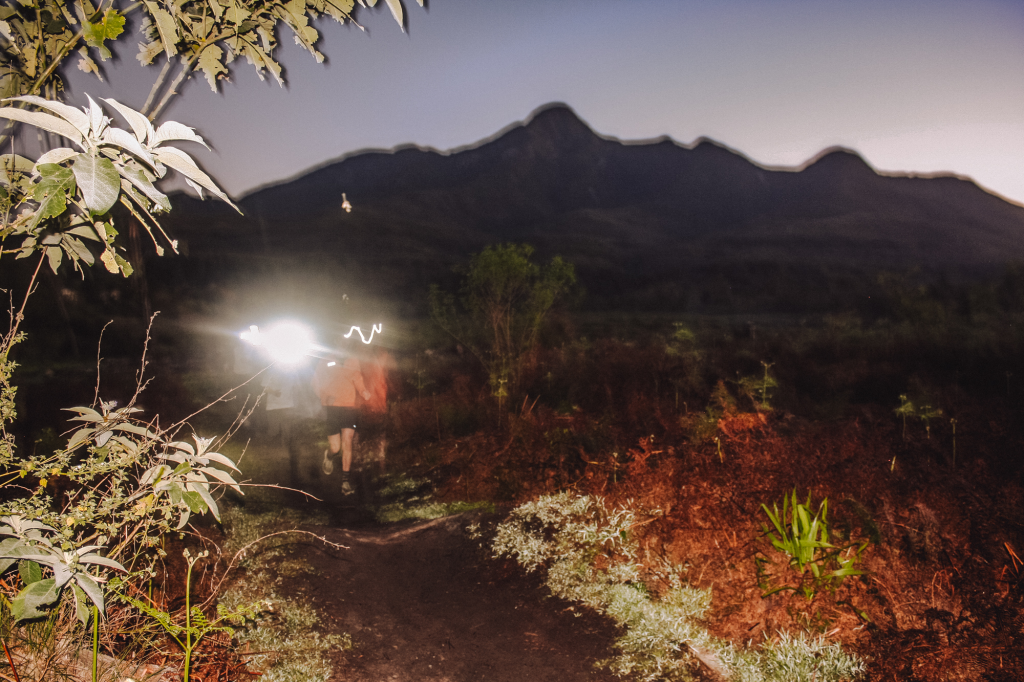 Strava Club hikers with headlamps on a mountain trail at night